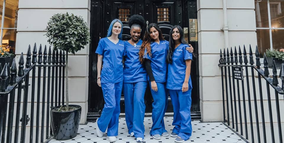 CoolSculpting fat freezing Amsterdam - four nurses in blue scrubs outside a Georgian clinic Four nurses in blue scrubs outside a Georgian clinic entrance for CoolSculpting fat freezing in Amsterdam